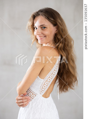 Young smiling woman posing against wall background 135091637