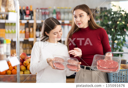 Mother and child choose cutlets and meat 135091676