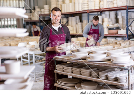 Young man posing with ceramic blanks Young man posing with ceramic blanks 135091693