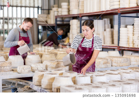 Young woman pouring clay into mold Young woman pouring clay into mold 135091698