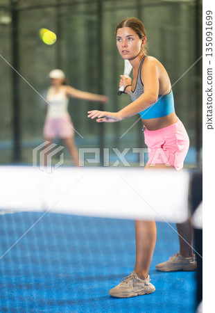 Young and adult women playing doubles tennis 135091699