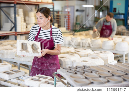 Young woman showing poured clay molds Young woman showing poured clay molds 135091747