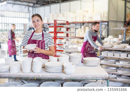 Young woman posing with ceramic blanks Young woman posing with ceramic blanks 135091886