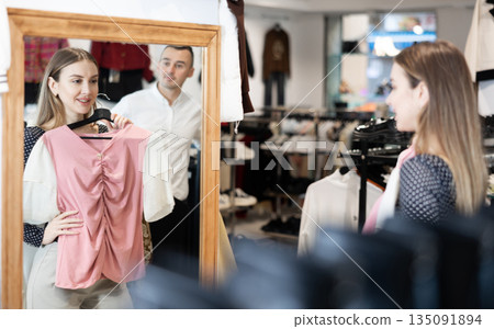 Couple young woman and young man choosing blouse Couple young woman and young man choosing blouse 135091894