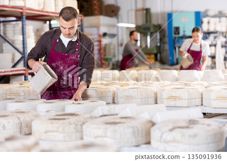 Young man pouring clay into mold 135091936