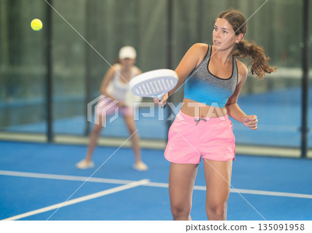 Young and adult women playing doubles tennis 135091958