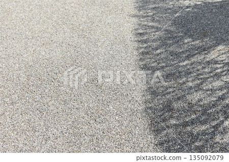 Gravel ground background material where the shade of trees falls 135092079
