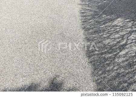 Gravel ground background material where the shade of trees falls Gravel ground background material where the shade of trees falls 135092125