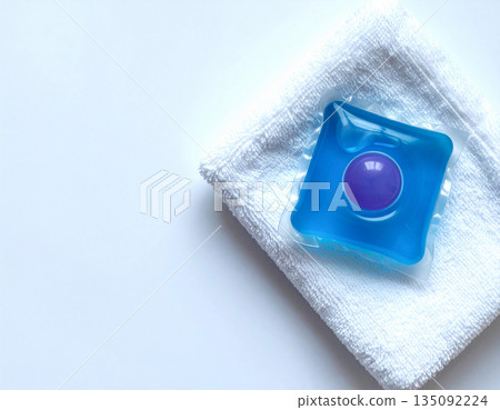 Laundry bleaching. Soluble laundry detergent capsule on a neutral linen cloth with empty space for text. 135092224