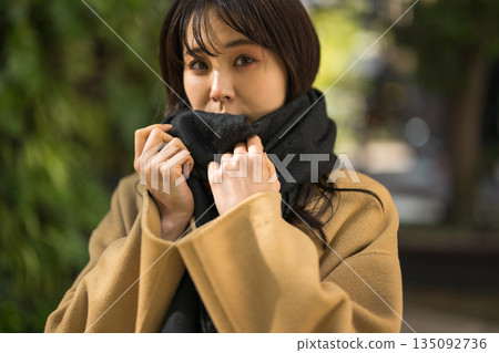 A woman wearing a scarf in the cold winter A woman wearing a scarf in the cold winter 135092736