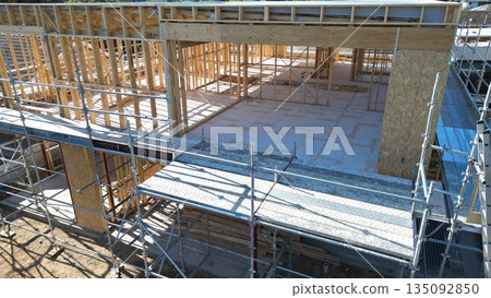 Wooden house construction site: Frame structure of a newly built detached house Wooden house construction site: Frame structure of a newly built detached house 135092850