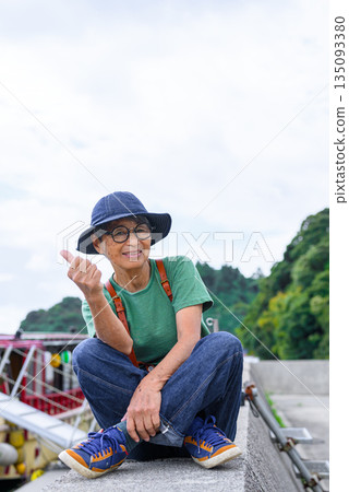 An elderly woman squatting at the harbor (Photo courtesy of Oki Seaside Resort Miyabi) An elderly woman squatting at the harbor (Photo courtesy of Oki Seaside Resort Miyabi) 135093380