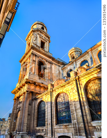 Church of Saint Sulpice stands in the 6th district of Paris, France. Historic stone architecture features the south tower and columns illuminated by golden sunset light Church of Saint Sulpice stands in the 6th district of Paris, France. Historic stone architecture features the south tower and columns illuminated by golden sunset light 135093496
