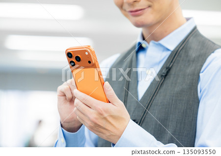 A man operating the latest smartphone A man operating the latest smartphone 135093550