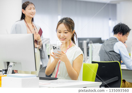 一個女人在辦公室裡操作智能手機 一個女人在辦公室裡操作智能手機 135093560