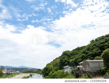 清爽的夏日藍天白雲,鬱鬱蔥蔥的青山,以及河畔村莊 清爽的夏日藍天白雲,鬱鬱蔥蔥的青山,以及河畔村莊 135094204