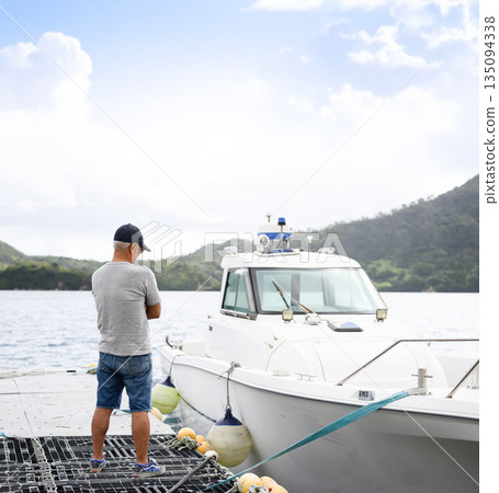 A man watches a boat from the pier. (Photo courtesy of Oki Seaside Resort Miyabi) A man watches a boat from the pier. (Photo courtesy of Oki Seaside Resort Miyabi) 135094338