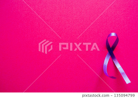 Purple ribbon on a pink background. Symbolizes World Cancer Day, observed on February 4th. The ribbon is prominently displayed, emphasizing awareness and support. 135094799