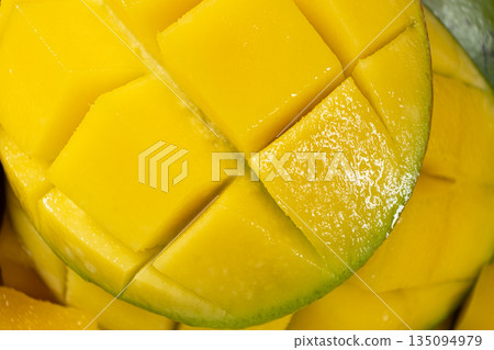 Juicy mango halves with cube cut pattern. Juicy mango halves with cube cut pattern. 135094979