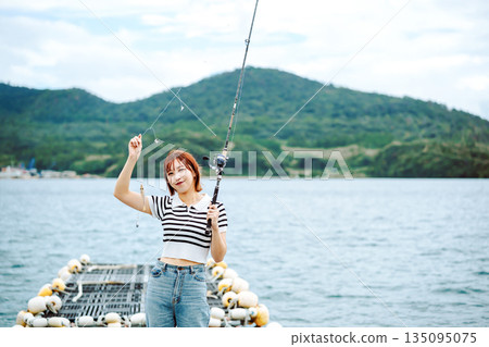 一位女士在海灘享受釣魚的樂趣（照片由沖繩海濱度假村雅提供） 135095075