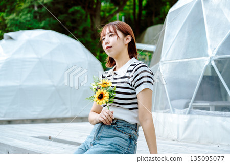 Dome tent and a woman holding sunflowers (Photo courtesy of Oki Seaside Resort Miyabi) 135095077