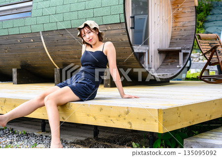 一位女士坐在桑拿房的平台上。 （圖片由沖繩海濱度假村雅提供） 135095092