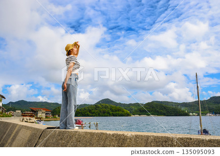 A woman looks up at the sky at the beach. (Photography courtesy of Oki Seaside Resort Miyabi) A woman looks up at the sky at the beach. (Photography courtesy of Oki Seaside Resort Miyabi) 135095093