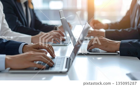 Close-up of a businessman's hands typing on a laptop keyboard in the office, illustrating business communication and technology work 135095287