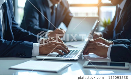 Close-up of a businessman's hands typing on a laptop keyboard in the office, illustrating business communication and technology work Close-up of a businessman's hands typing on a laptop keyboard in the office, illustrating business communication and technology work 135095288