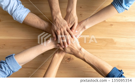 Group of people holding hands together in support and teamwork Group of people holding hands together in support and teamwork 135095354