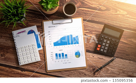 Businessman's office desk with a laptop, calculator, and financial documents showing market data and graphs Businessman's office desk with a laptop, calculator, and financial documents showing market data and graphs 135095356