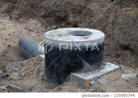 Construction of a concrete septic tank installation site in a residential area during daylight hours Construction of a concrete septic tank installation site in a residential area during daylight hours 135095744