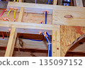 Construction work showing electrical, plumbing installations in wooden beams at building site 135097152