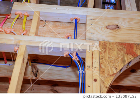 Construction work showing electrical, plumbing installations in wooden beams at building site Construction work showing electrical, plumbing installations in wooden beams at building site 135097152