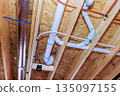Pipes and ducts installed in ceiling of construction site plumbing and HVAC systems in progress 135097155