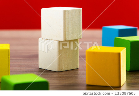 Wooden toy blocks forming a structure on table 135097603
