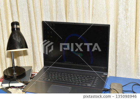 Home environment. The laptop is on the desk. 135098946