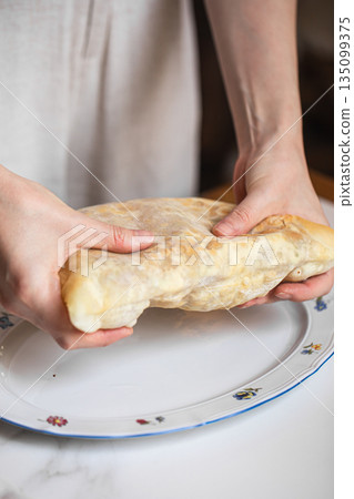 Georgian cheese flatbread roll served by hands Georgian cheese flatbread roll served by hands 135099375