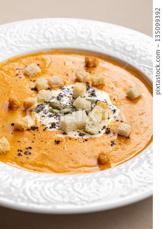 Creamy pumpkin soup with sour cream garnish Creamy pumpkin soup with sour cream garnish 135099392