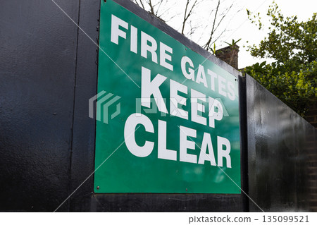 Fire Gates Keep Clear Green Safety Sign on Black Metal Fence Fire Gates Keep Clear Green Safety Sign on Black Metal Fence 135099521