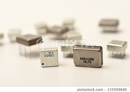 Old chips on a white background. Different electronic chips. Microcircuits in a metal case. 135099686