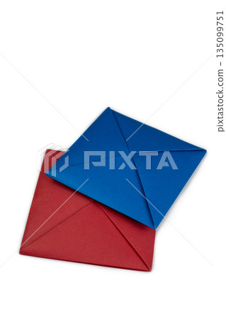 Red and blue square for two players in Ddakji on white background. Vertical photo of two player game from South Korea. Fold colored sheets of paper to create squares for game Red and blue square for two players in Ddakji on white background. Vertical photo of two player game from South Korea. Fold colored sheets of paper to create squares for game 135099751