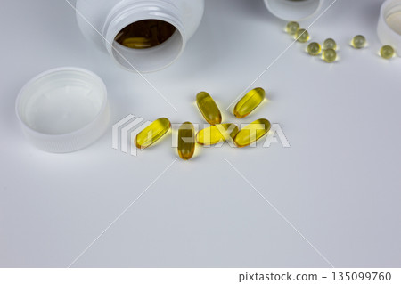 Omega 3 capsules in front of jar on white background. Medical background with vitamins for taking with meal. Pharmacy background, universal vitamins for people 135099760