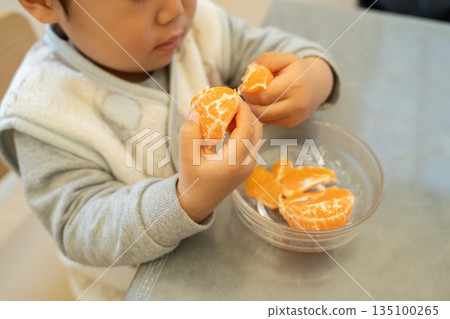 Toddler eating tangerines Toddler eating tangerines 135100265