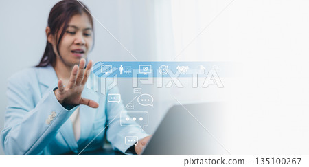 Asian business woman using laptop for virtual meeting or online webinar. Concept of digital marketing strategy, business training, and communication with cloud icons on white background. Asian business woman using laptop for virtual meeting or online webinar. Concept of digital marketing strategy, business training, and communication with cloud icons on white background. 135100267