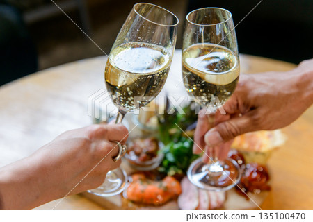 Toasting with sparkling wine, horizontal composition Toasting with sparkling wine, horizontal composition 135100470