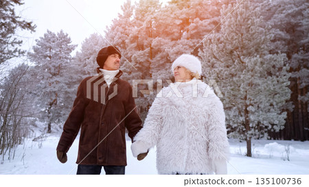 Pair Watching Snowy Dawn Together, Couple Observing Icy Sunrise Amid Pine Trees With Cheerful Expressions, Pair Of Friends Reveling In Frosty Morning Glow While Dressed Warmly In Nature 135100736