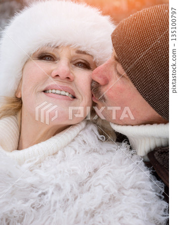 Lovers Exchanging Affection In Cold Weather, Couple Displaying Warmth And Love During Chilly Winter Day, Man And Woman Sharing Tender Kiss On Cheek Amidst Relaxed Winter Atmosphere Lovers Exchanging Affection In Cold Weather, Couple Displaying Warmth And Love During Chilly Winter Day, Man And Woman Sharing Tender Kiss On Cheek Amidst Relaxed Winter Atmosphere 135100797
