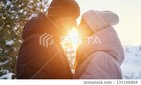 Couple Enjoying Warm Sunset, Tender Glance Shared By Partners Amid Snowy Pine Trees, Sunlit Couple Exchanging Affectionate Looks Surrounded By Snowcovered Pine Trees During Golden Hour Couple Enjoying Warm Sunset, Tender Glance Shared By Partners Amid Snowy Pine Trees, Sunlit Couple Exchanging Affectionate Looks Surrounded By Snowcovered Pine Trees During Golden Hour 135100804