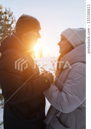 Couple Holding Hands At Sunset, Warm Backlight Creating Silhouette Effect As Partners Exchange Meaningful Gaze And Gentle Touch, Winter Coats And Knit Hats Framing Candid Romantic Moment, Soft Golden Couple Holding Hands At Sunset, Warm Backlight Creating Silhouette Effect As Partners Exchange Meaningful Gaze And Gentle Touch, Winter Coats And Knit Hats Framing Candid Romantic Moment, Soft Golden 135100811